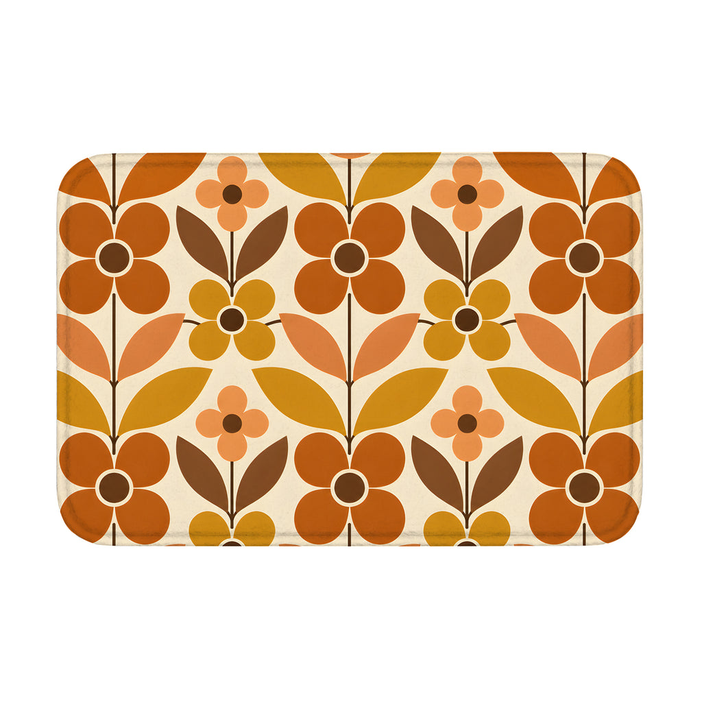 A rectangular mid-century modern style doormat with a bold geometric floral pattern in retro burnt orange, mustard yellow, and brown on a cream background.