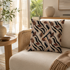 An abstract zebra stripe and brown leaf print pillow styled on a modern cream armchair with rattan woven armrests, set in a bright living room near a sunny window.