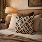 An abstract zebra stripe and brown autumn leaf accent pillow arranged on a cozy bed with a beige tufted headboard, neutral linens, and a glowing warm bedside lamp.