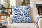 Blue & White Bat Floral Printed Pillow Cover, lifestyle view 1: Placed upright on an accent chair, nearly frontal with full print clearly visible; room-wide interior composition.