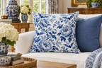 Blue & White Bat Floral Printed Pillow Cover, lifestyle view 2: A prominent single pillow on a sofa beside one plain solid-colored cushion; medium interior composition, product fills at least 40 percent of frame.