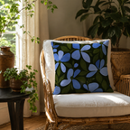 Blue floral accent pillow cover on a bohemian style rattan chair by the window.