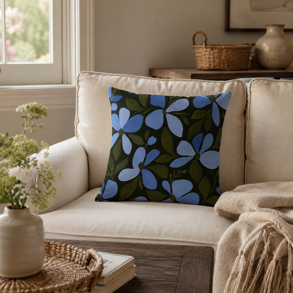 Blue floral decorative pillow cover on a cream sofa in a cozy living room setting.