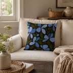 Blue floral decorative pillow cover on a cream sofa in a cozy living room setting.