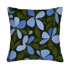 Square blue floral pillow cover with dark green leaves isolated on a white background.