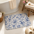 Blue toile floral floor mat beside a cozy bathtub.