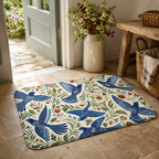 A chintz style bluebird doormat placed on a stone tiled entryway near an open wooden front door.