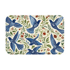A rectangular doormat featuring a vintage bluebird and floral pattern with intricate green leaf vines.