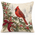 Christmas cardinal pillow cover with snowy pine, berries and a burgundy bow, shown on a white background.