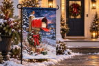 Christmas Mailbox Printed Garden Flag, lifestyle view 1: One flag on a simple separate black L-shaped garden stake beside a front porch planter, all of the flag readable, late-afternoon natural light.