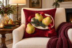 Christmas Pear & Ribbon Printed Velvet Pillow Cover, lifestyle view 1: Placed upright on an accent chair, nearly frontal with full print clearly visible; room-wide interior composition.