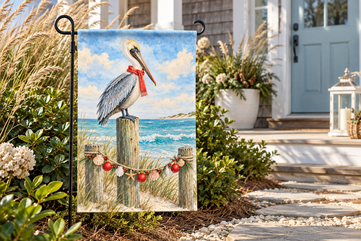 Coastal Pelican Christmas Printed Garden Flag, lifestyle view 2: One flag on a separate black garden stake along a short garden path, lower garden view with planting behind; no people, full rectangle visible.