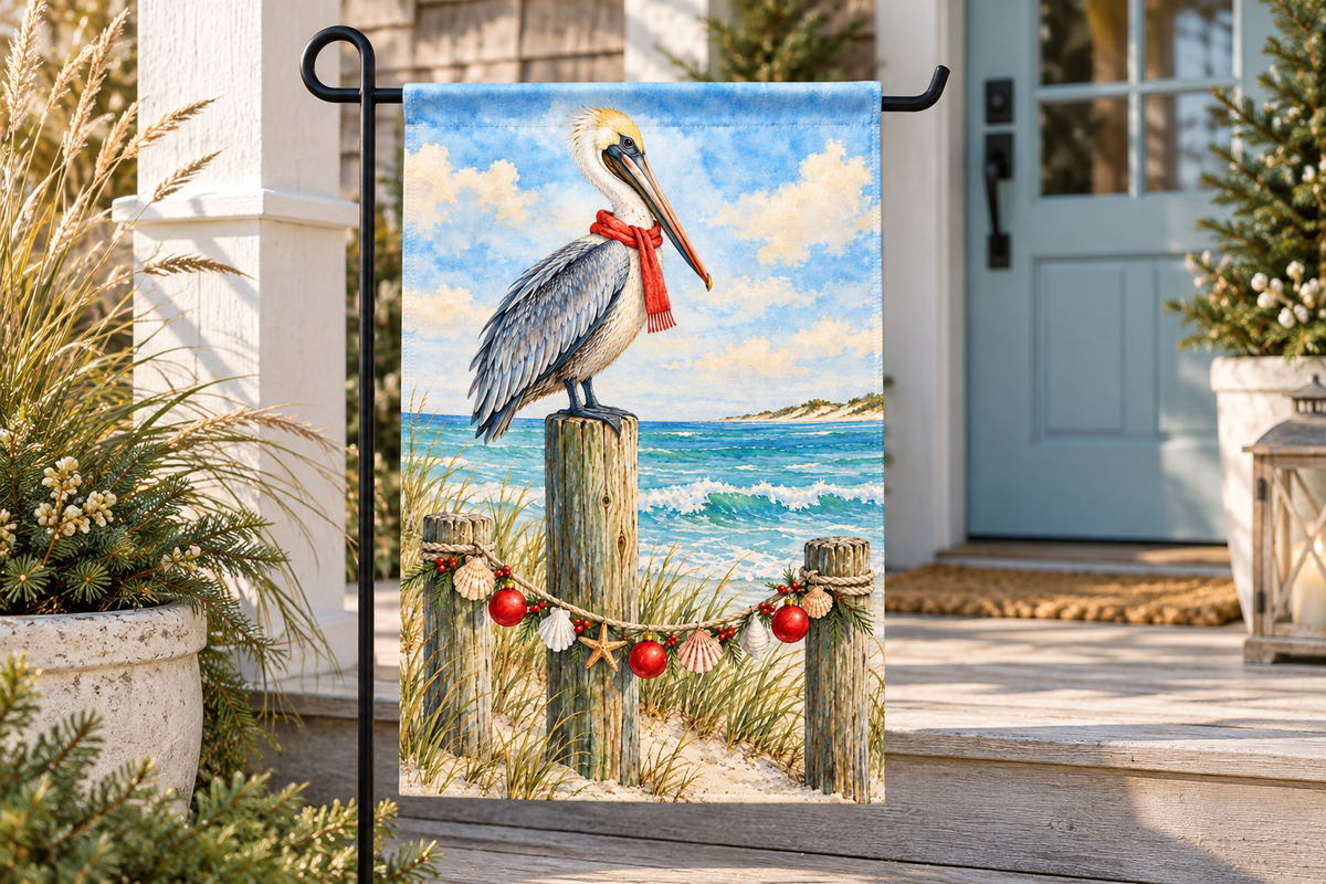 Coastal Pelican Christmas Printed Garden Flag, lifestyle view 3: Closer view of the flag on its separate black L-shaped stake near a porch post, the real cloth top sleeve threading over the horizontal bar, print clearly readable.