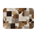 A rectangular doormat with a brown and white faux cowhide patchwork pattern on a white background.