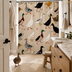 A playful duck illustration shower curtain hung in a modern bright bathroom with a light wood vanity, a beige floor mat, and a real duck standing on the tiles.