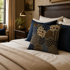 A vintage ethnic patterned accent pillow arranged on a cozy bed with deep blue pillowcases and a textured brown blanket, next to a dark wood headboard and classic brass lamp.