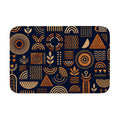 A rectangular doormat featuring abstract orange geometric shapes and lines on a dark blue background.