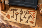 Haunted House Antique Keys Printed Floor Mat, lifestyle view 4: Close overhead-oblique view of one mat on a clean pale-wood floor near a cabinet, all four corners in frame, soft side light reveals short flannel nap.