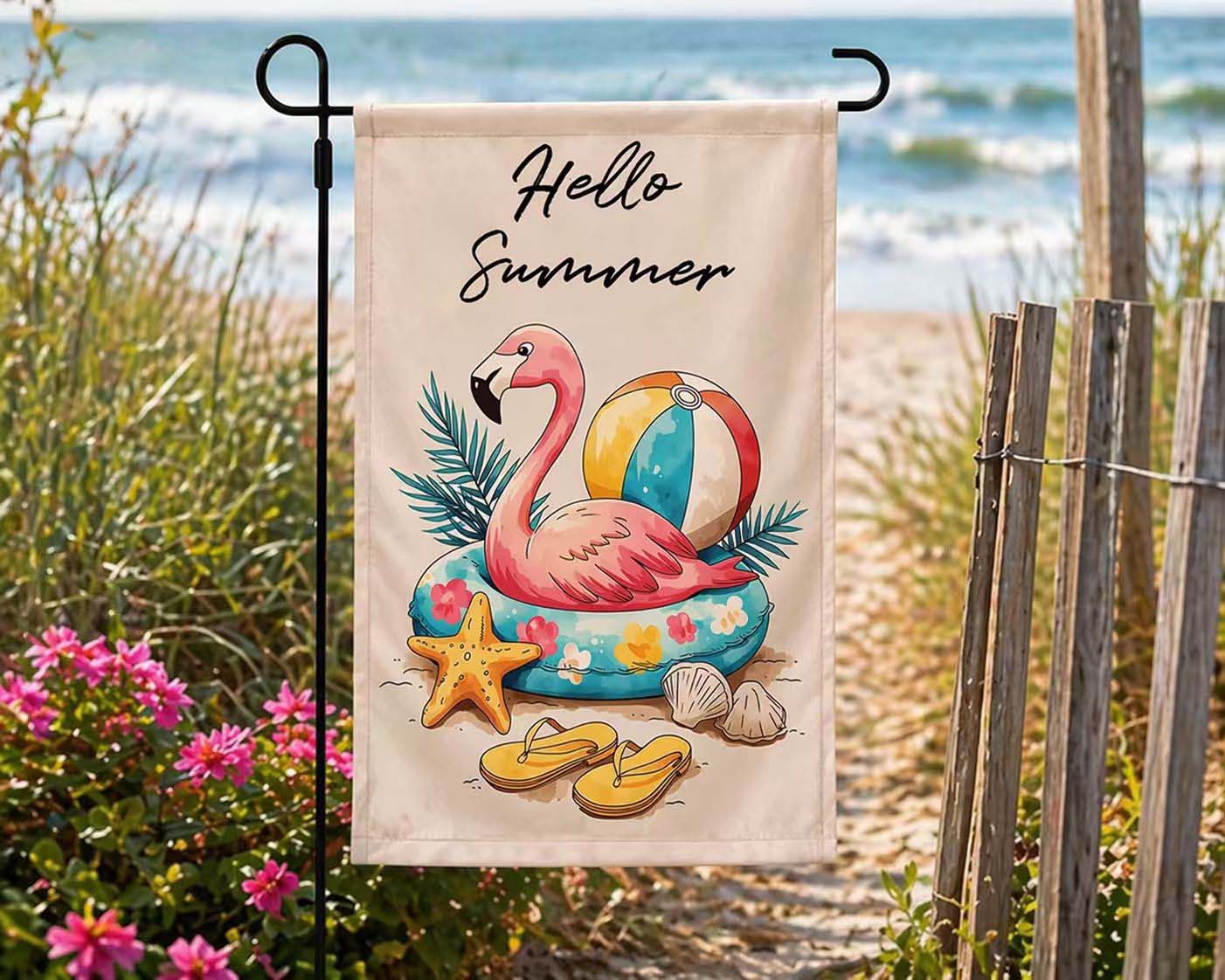 Hello Summer flamingo garden flag displayed near a coastal beach path