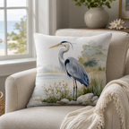Heron pillow cover styled on a bright coastal-inspired armchair beside large windows.