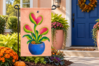 Monster Venus Flytrap Printed Garden Flag, lifestyle view 4: One flag on its separate black garden stake in a mailbox garden with restrained October seasonal planting, wide but product-led welcoming suburban scene.