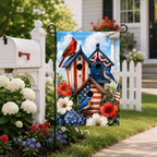 Patriotic birdhouse garden flag installed in a flower bed next to a rustic white wooden mailbox.