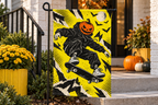 Pumpkin Skateboard Printed Garden Flag, lifestyle view 3: Closer view of the flag on its separate black L-shaped stake near a porch post, the real cloth top sleeve threading over the horizontal bar, print clearly readable.