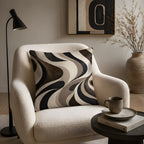 A retro abstract wavy lines accent pillow styled on a stylish cream bouclé armchair, paired with a sleek black floor lamp and a dark side table with a ceramic coffee mug.