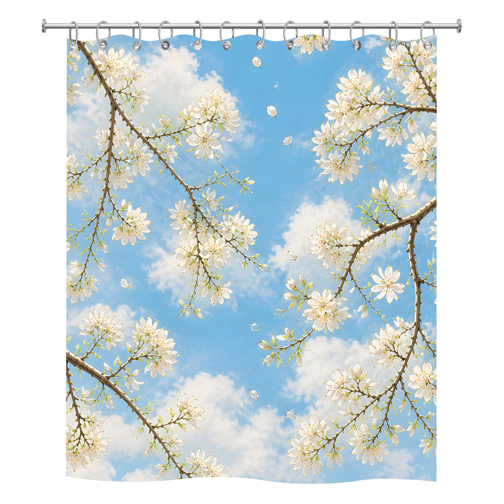 Front view of a white fabric shower curtain with a vibrant print of white tree blossoms against a bright blue sky with fluffy clouds.