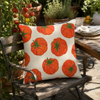 Tomato pattern pillow cover styled on a rustic wooden chair in an outdoor garden setting.