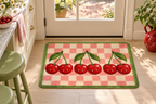 Vampire Cherry Check Printed Floor Mat, lifestyle view 1: One mat laid flat INSIDE the front door, full landscape mat and all four rounded corners visible at small accent-mat scale, angled downward photography.
