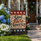 Antique look "God Bless America" holiday flag on a stake along a stone paver walkway leading to a traditional wooden front door with a wreath.