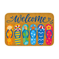 A rectangular summer welcome doormat featuring six colorful beach flip-flops with ocean themes on a coir-textured background.